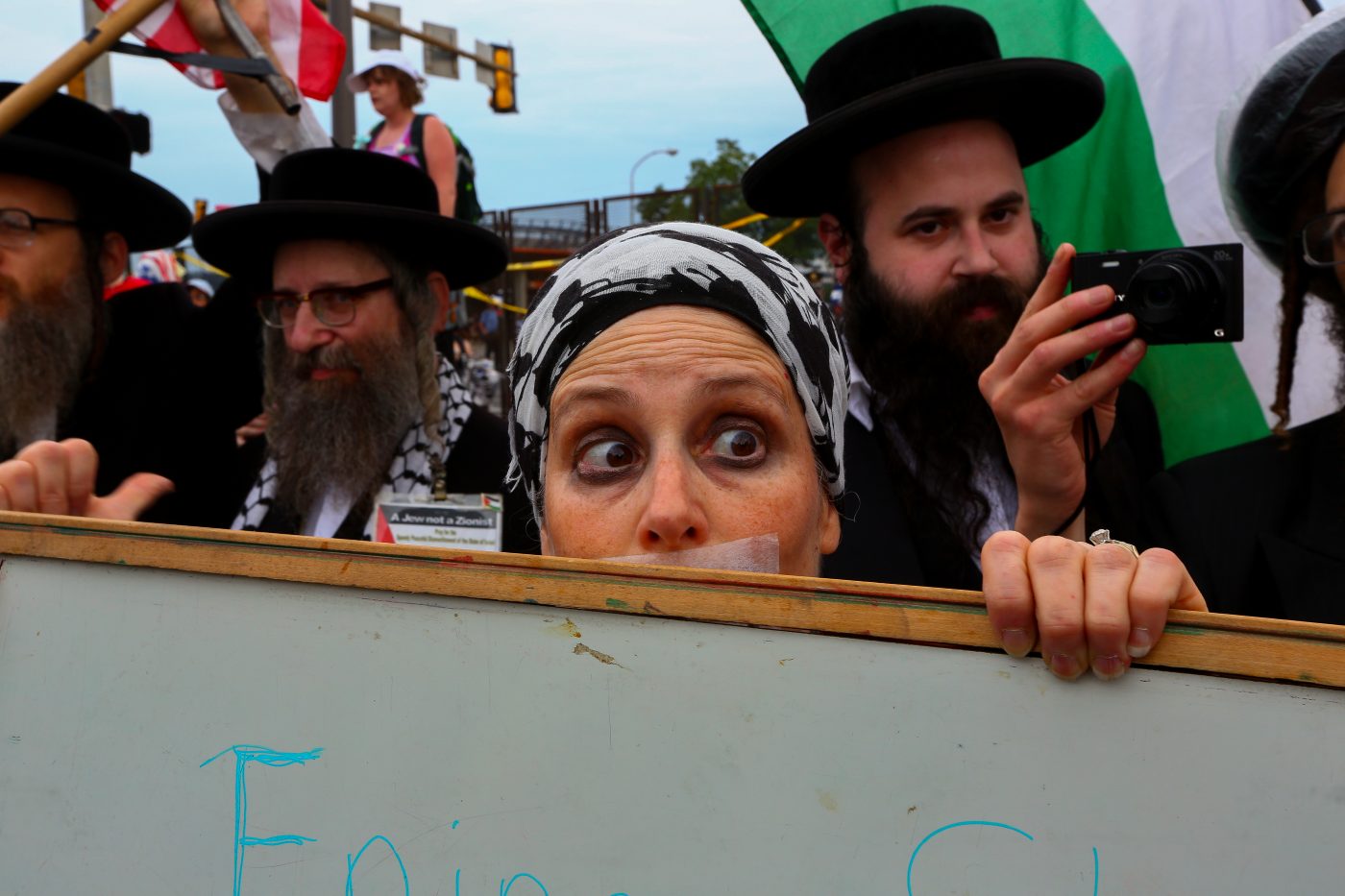 A woman walks slowly between two opposing groups of Jewish demonstrators, both for and against the state of Israel, on the last day of the 2016 Democratic National Convention in Philadelphia, July 28.